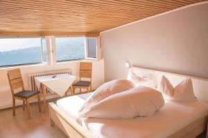 思科纳Schenna Garni Eden Bed & Breakfast的一间卧室配有一张带白色床单的床和一扇窗户。