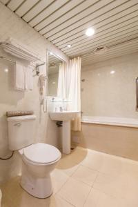 中和S.L饭店的浴室配有卫生间、盥洗盆和浴缸。