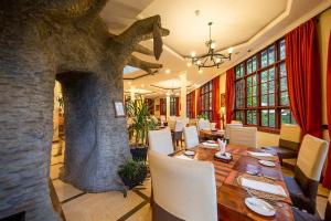 阿鲁沙非洲郁金香宾馆的一间带桌子和石头壁炉的用餐室