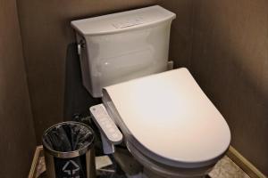 上海锦江都城经典上海南京饭店的浴室内的白色卫生间,配有遥控器