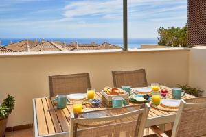贝纳尔马德纳Sea View Penthouse, Pool, Privacy, Benalmadena的阳台上的桌子上摆放着食物和橙汁