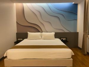 合艾Lee Gardens Plaza Hotel - SHA Plus的一间卧室配有一张壁画床