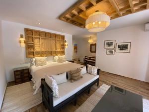 奥伊俄贞Domaine de la Roseraie Resort的一间卧室配有一张床和一个沙发