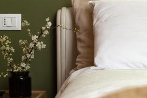 兰恰诺Lotus House的一张带白色枕头的床和花瓶