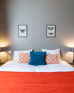 雷克雅未克雷夫瑞克森酒店的一间卧室配有带橙色和蓝色枕头的床