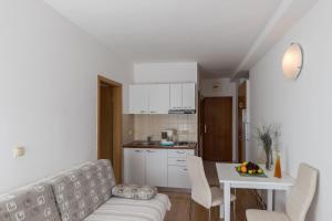 斯拉诺Apartments & Room Eva Slano的厨房以及带桌子和沙发的客厅。