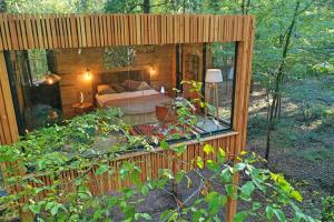埃斯夫尔Loire Valley Lodges - Hotel的树林中的房屋,享有卧室的景色