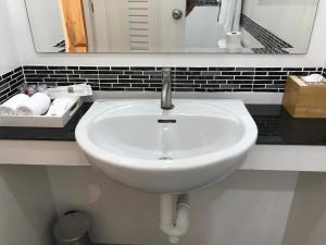 华欣Origin hua hin poolvilla的浴室设有白色水槽和镜子