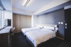松山Hotel Kajiwara的酒店客房设有两张床和窗户。