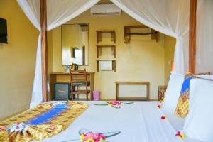 乌罗阿Filao Beach by Sansi的一间卧室配有一张铺有白色床单和鲜花的床。