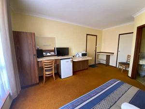DonnybrookDonnybrook Motel的酒店客房配有一张床和一张书桌,