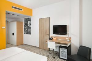 布达佩斯布达佩斯丽笙布鲁酒店的客房设有1张床、1张办公桌和1台电视。