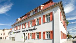 路德维希堡凯普威 - 酒店及公寓的白色的建筑,上面有橙色百叶窗