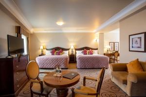 纳斯劳勒斯酒店的酒店客房设有两张床和一张桌子。