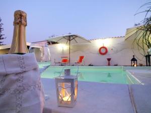 罗戈·格兰德齐亚皮娅乡间别墅酒店的一瓶香槟和游泳池旁的灯笼