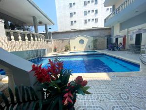巴兰基亚Hotel Puerta de Oro的一座花卉游泳池,位于一座建筑的一侧