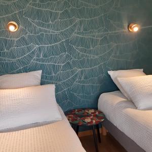 CabariotLa Clé du Puy的一间卧室设有两张床,墙上贴着蜘蛛网壁纸。