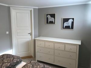 诺托登Notodden Sentrum Apartment NO 3的一间带白色梳妆台和白色门的卧室