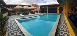 巴纳伊巴Hotel Pousada Dos Ventos的一座带椅子的游泳池以及一座建筑