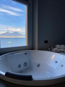 那不勒斯Relais sul Mare Boutique Hotel的带窗户的浴室内的白色大浴缸