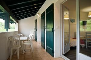 萨尔VVF Pays Basque Sare La Rhune的配有桌椅和绿门的房间