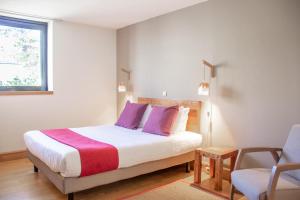波尔多波尔多中心维多利亚花园酒店的一间卧室配有一张带紫色枕头的床和一把椅子