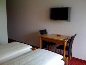 旺斯汪斯公园酒店的客房设有桌子、小桌子和电视。