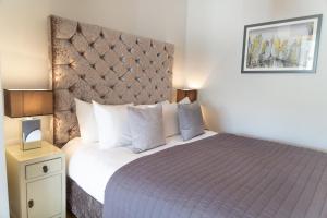 剑桥Citystay - Marino Place的一间卧室配有一张大床和紫色床罩