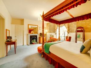 巴斯OYO Bailbrook Lodge, Bath的一间卧室设有一张天蓬床和一个壁炉