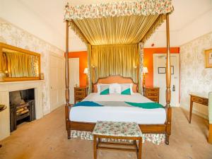 巴斯OYO Bailbrook Lodge, Bath的一间卧室设有一张天蓬床和一个壁炉
