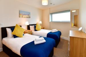 斯旺西Just Stay Wales - Meridian Quay Apartments的酒店客房,配有两张带毛巾的床