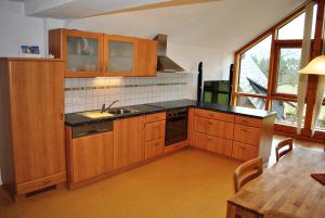 滨湖伦茨Ferienwohnung Leitner的厨房配有木制橱柜、水槽和桌子
