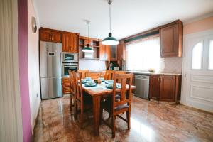 马斯帕洛马斯Villa Morada Sonneland con piscina privada climatizada的厨房配有桌椅和冰箱。