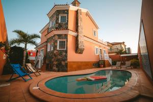 马斯帕洛马斯Villa Morada Sonneland con piscina privada climatizada的房屋前有游泳池的房子