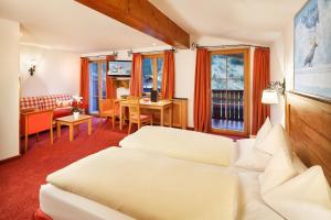 莱赫阿尔贝格莱赫及樵萨罗莎酒店的酒店客房设有床和客厅。