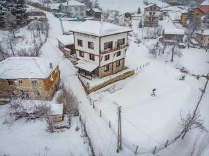 ManastirGuesthouse Vazrozhdenski kashti的雪中房屋的空中景观