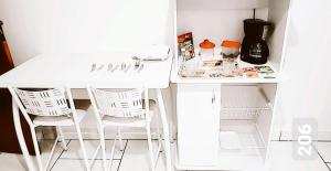 新弗里堡Cantinho Suico Aluguel de Temporada的厨房里配有一张白色的桌子和两把白色的椅子
