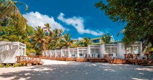 圣安德烈斯Hotel Reina del Mar By Dorado的海滩上带桌椅的度假村