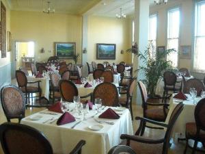 Del Norte温莎酒店及餐厅的用餐室配有桌椅和白色的桌布