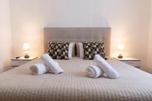 奥良OceanOasis的一间卧室配有一张带白色枕头的床和两盏灯。