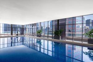 墨尔本曼特拉南岸酒店的一座带窗户的建筑中央的游泳池