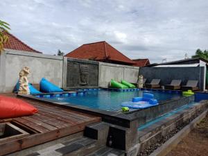 蓝梦岛Devadav Hostel (Bunk Bed) Nusa Lembongan的一个带椅子的游泳池和一个游泳池