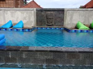 蓝梦岛Devadav Hostel (Bunk Bed) Nusa Lembongan的中间设有一座带雕像的游泳池