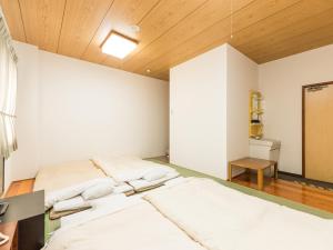 伊势崎市Hotel Isesaki East的配有木天花板的客房设有两张床。