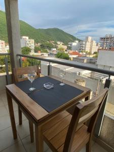 萨尔塔Luxury Appart的阳台上的木桌和两杯酒杯