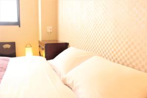 东京K's House Tokyo Oasis - Asakusa Downtown的卧室配有一张带床头板的白色床