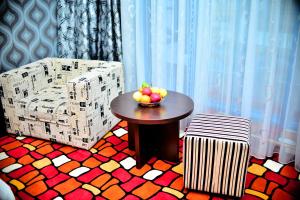 奇姆肯特萨帕尔标准酒店的一间房间,配有一张桌子和一把椅子,还有一碗水果