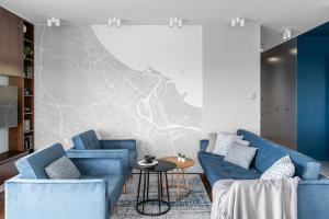 格但斯克Sea view apartment的客厅配有2张蓝色的沙发和1张桌子