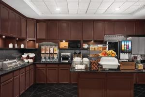 绍姆堡伊利诺伊州绍姆堡卡尔森江山套房酒店的厨房配有棕色橱柜和水果台