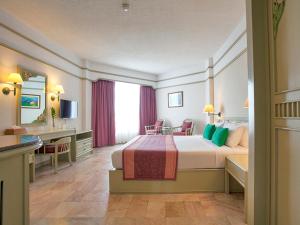 纳库鲁阿Cholchan Pattaya Beach Resort - SHA Extra Plus的酒店客房设有一张大床和一张书桌。